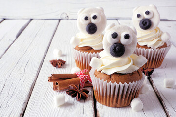 Poster - Winter Polar Bear cupcakes. Close up on a rustic white wood table background.