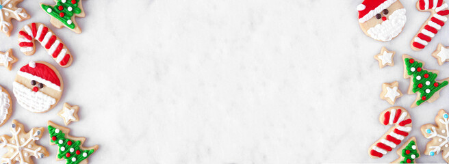 Leinwandbilder - Cute Christmas cookie double border. Above view on a white marble banner background with copy space. Holiday baking concept. Santa Claus, tree, snowflakes, candy canes, stars.