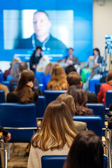 Canvas Print - Businesspeople watching online conference in auditorium