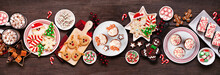 Cute Christmas Sweets And Cookie Table Scene. Top View On A Rustic Dark Wood Banner Background. Fun Holiday Baking Concept.
