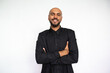 © KAMPUS - Portrait of confident young man crossing arms. Proud Latin American male model with bald head and beard in black shirt looking at camera with crossed arms. Self-assurance concept