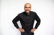 © KAMPUS - Portrait of excited young man with hands on waist. Happy multiethnic male model with bald head and beard in black shirt looking at camera, bending and smiling. Self-assurance, success concept.
