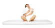 © New Africa - Young woman on soft mattress holding pillow against white background