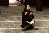 Fototapeta Tulipany - Humble Muslim Woman is Praying in the Mosque