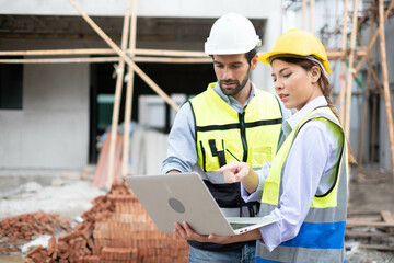 Engineers on building site. Engineer are working contruction on site plans to build high-rise buildings building. Architect caucasian man working with colleagues mixed race in the construction site.