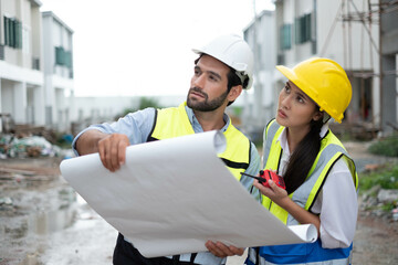 Wall Mural - Engineers on building site. Engineer are working contruction on site plans to build high-rise buildings building. Architect caucasian man working with colleagues mixed race in the construction site.