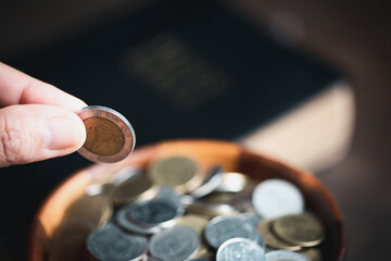 Wall Mural - One tenth or tithe is basis on which Bible teaches us to give one tenth of first fruit to God. coins with Holy Bible. Biblical concept of Christian offering, generosity, and giving tithes in church.