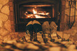 Happy couple sitting at home by fireplace, warm and cozy relaxing together. Cold winter in Europe concept. Wood stove using during energy crisis and high prices on gas.