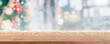 Empty wood table top on blur with bokeh Christmas tree and new's year decoration on window banner background with snowfall - can be used for display or montage your products.