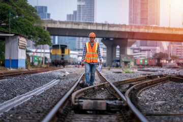 Wall Mural - Engineer under inspection and checking construction process railway switch and checking work on railroad station .Engineer wearing safety uniform and safety helmet in work.