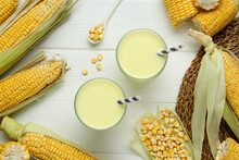 Flat Lay Composition With Tasty Fresh Corn Milk In Glasses On White Wooden Table