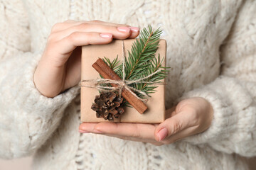 Wall Mural - Christmas present. Woman holding beautifully wrapped gift box, closeup