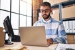 © Krakenimages.com - Young hispanic man ecommerce business worker using laptop working at office