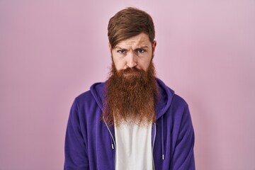 Canvas Print - Caucasian man with long beard standing over pink background skeptic and nervous, frowning upset because of problem. negative person.