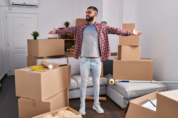 Wall Mural - Young hispanic man smiling confident standing with arms open at new home