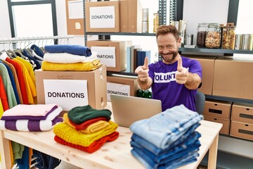 Poster - Middle age man wearing volunteer t shirt working with laptop pointing fingers to camera with happy and funny face. good energy and vibes.