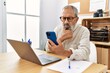 © Krakenimages.com - Senior grey-haired man using smartphone working at office