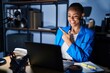 © Krakenimages.com - Beautiful african american woman working at the office at night cheerful with a smile of face pointing with hand and finger up to the side with happy and natural expression on face