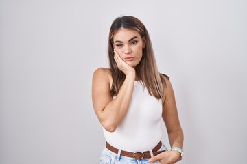 Poster - Hispanic young woman standing over white background thinking looking tired and bored with depression problems with crossed arms.