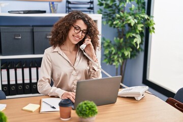 Sticker - Young hispanic woman business worker using laptop talking on telephone at office