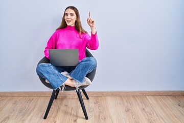 Sticker - Young hispanic girl working using computer laptop smiling amazed and surprised and pointing up with fingers and raised arms.