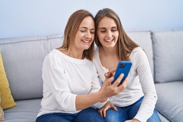 Canvas Print - Two women mother and daughter using smartphone at home