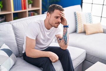 Canvas Print - Young hispanic man stressed sitting on sofa at home