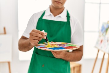 Poster - Young hispanic man mixing color at art studio