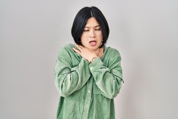 Canvas Print - Young asian woman standing over white background shouting suffocate because painful strangle. health problem. asphyxiate and suicide concept.