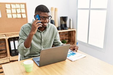 Canvas Print - Young african american man talking on the smartphone working at office