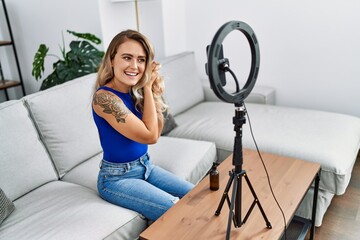 Sticker - Young woman recording hair care tutorial by smartphone at home