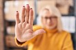 © Krakenimages.com - Middle age blonde woman ecommerce business worker doing stop gesture with hands at office