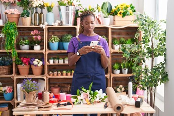 Canvas Print - African american woman florist using smartphone at florist