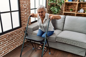 Wall Mural - Senior grey-haired woman patient supported for walker at geriatric