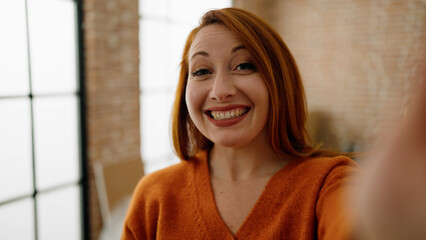 Young redhead woman smiling confident making selfie by the camera at new home