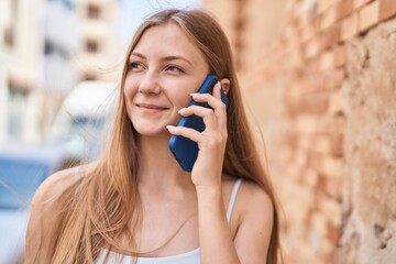 Canvas Print - Young caucasian woman smiling confident talking on the smartphone at street