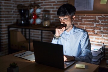 Sticker - Young hispanic man with beard working at the office at night feeling unwell and coughing as symptom for cold or bronchitis. health care concept.