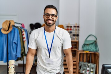 Canvas Print - Young hispanic man shopkeeper smiling confident working at clothing store