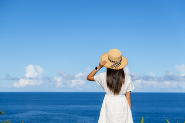 Sticker - Tourist woman with white dress and look at the sea at summer time