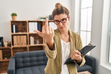 Wall Mural - Young woman working at consultation office showing middle finger, impolite and rude fuck off expression