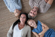 © ASDF - Family lying on floor with heads together at home
