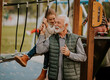 © BGStock72 - Grandfather spending time with his granddaughter in park playground on autumn day