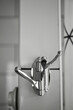 Wall stainless steel chromed triple hook on the white tile wall in the bathroom. Modern detail of interior design. Shiny accessory. Towels holder. Copy space