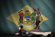 Delaware US state flag with statue of lady justice, constitution and judge hammer on black drapery. Concept of judgement and guilt