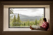 © rh2010 - Woman works on laptop while sitting on a window with great view on mountains. Remote work from cozy place and escaping to nature concept