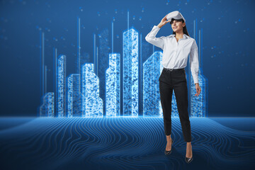  businesswoman with VR glasses standing on blue background with abstract creative pixel city hologram. Smart city, innovated building architecture, virtual reality and engineering concept.