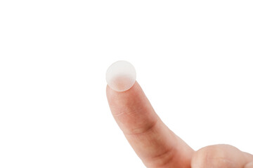 close-up round acne patch on finger on white background. acne patches for treatment of pimple and ro