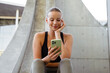 © Drobot Dean - Young beautiful smiling sporty woman holding and using her phone