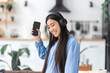 © kucherav - Happy carefree freedom young woman in headphones dancing at home in the kitchen alone having fun. Vacation, weekend home concept