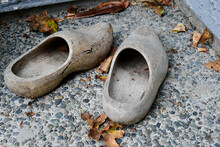 A Pair Of Hand Carved Wooden Shoes That Are Faded And Weathered.